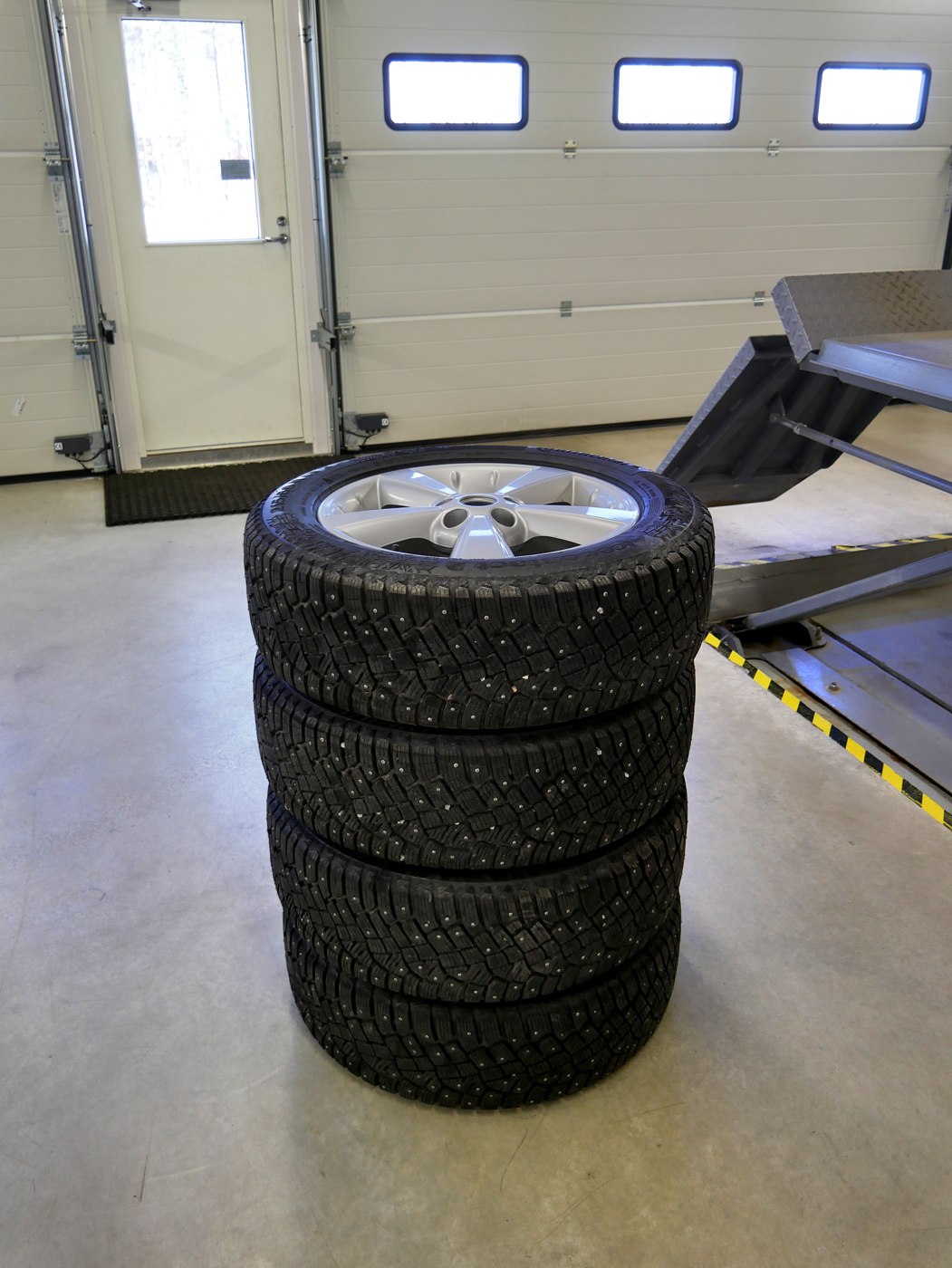 A stack of complete wheels in a garage