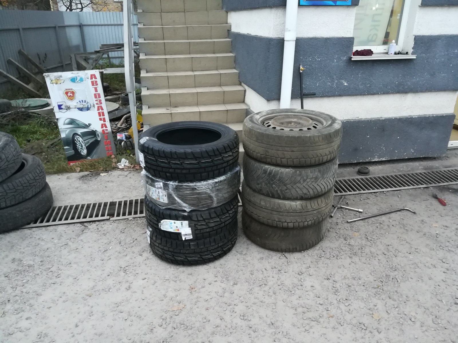 Old and new tyres during replacement outside a workshop