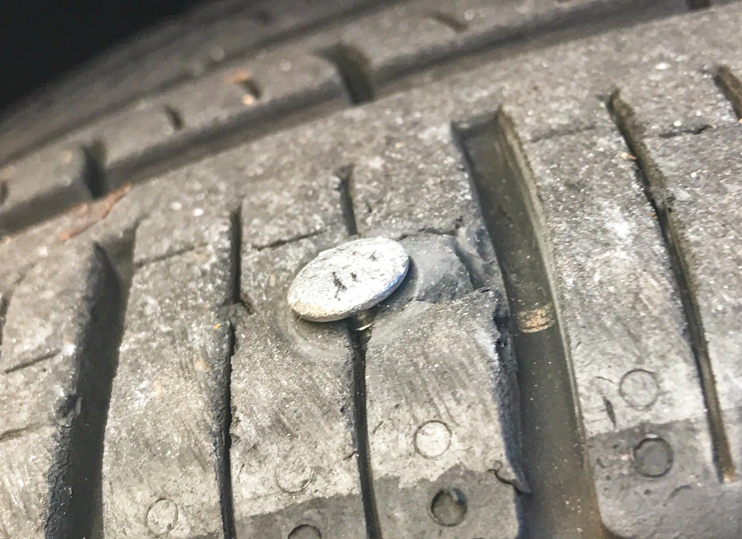 Metal object embedded in tyre tread