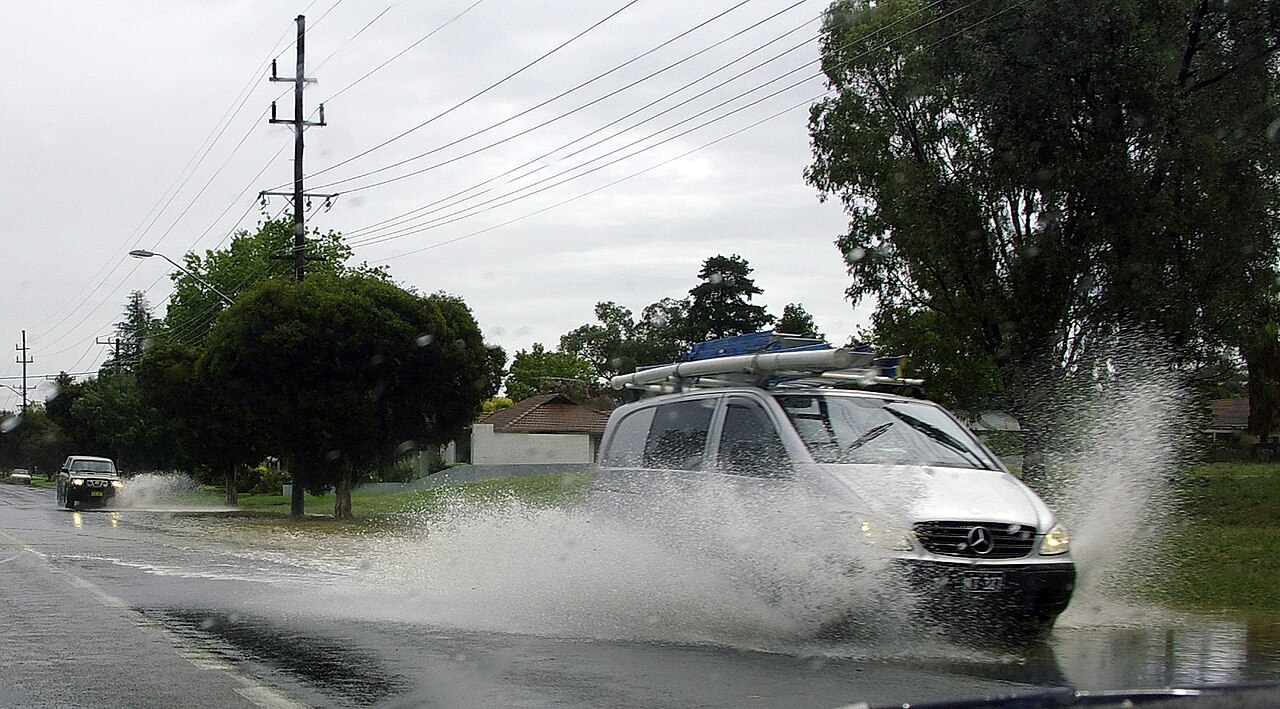 Vehicles passing through standing water on a road