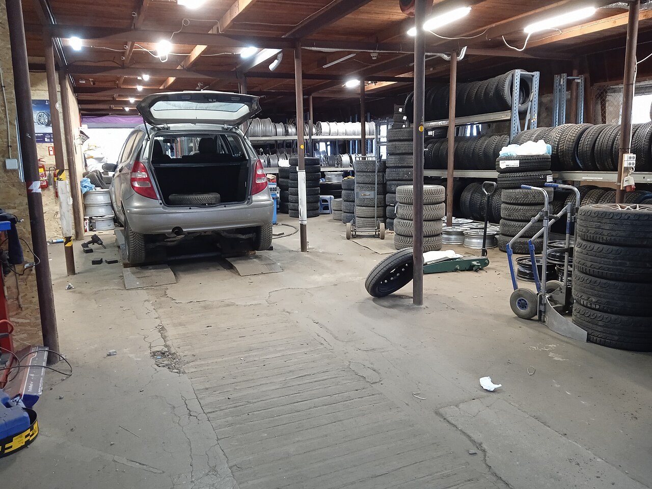 Tyre racks and a vehicle inside a tyre workshop in Riga